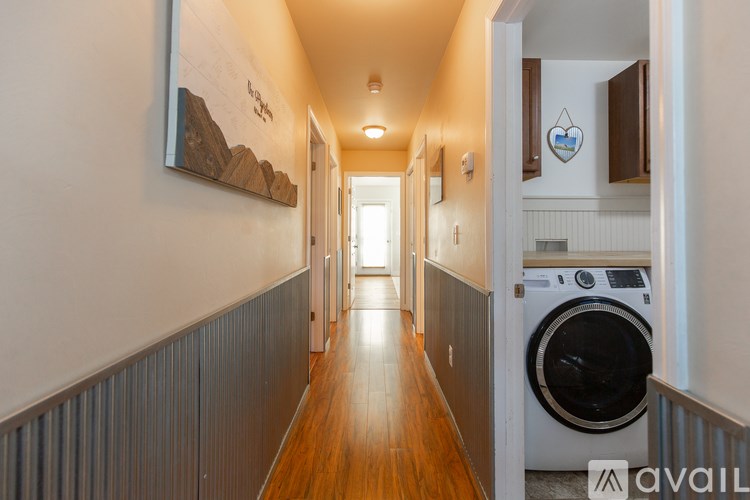A hallway with a washing machine in the doorway.