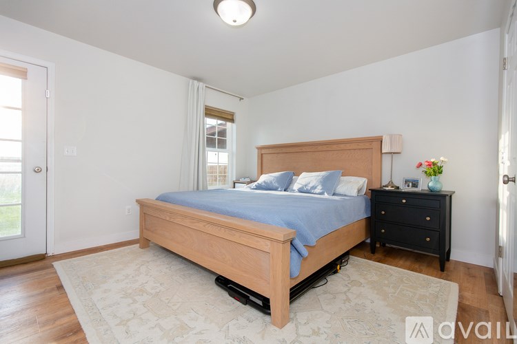 A bedroom with a bed, nightstand, and rug.