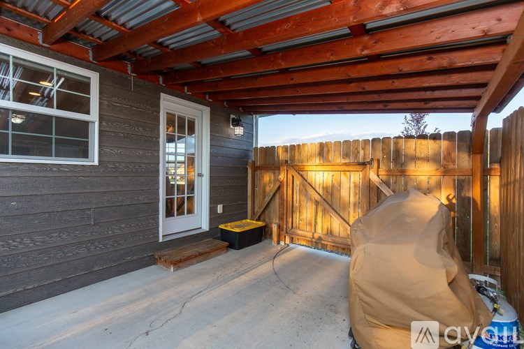 A patio with a wooden fence and a covered area.