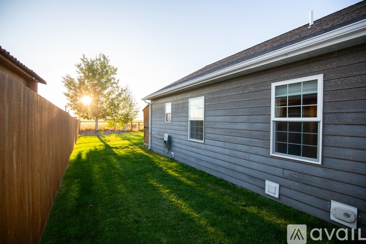 A house with a grey exterior and a green lawn.