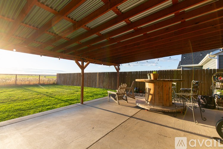 A covered patio area with a table and chairs.