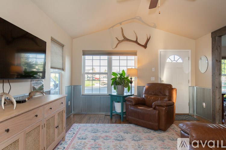 A living room with a brown leather chair and a wooden cabinet.