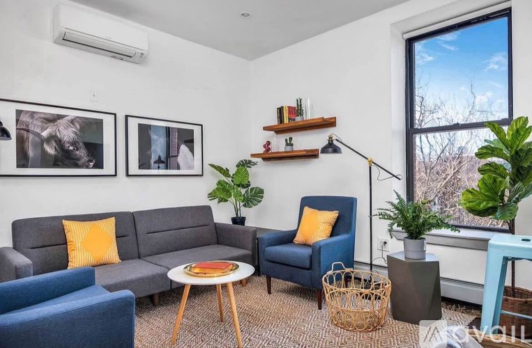 A living room with a grey couch, blue armchair, and a coffee table.