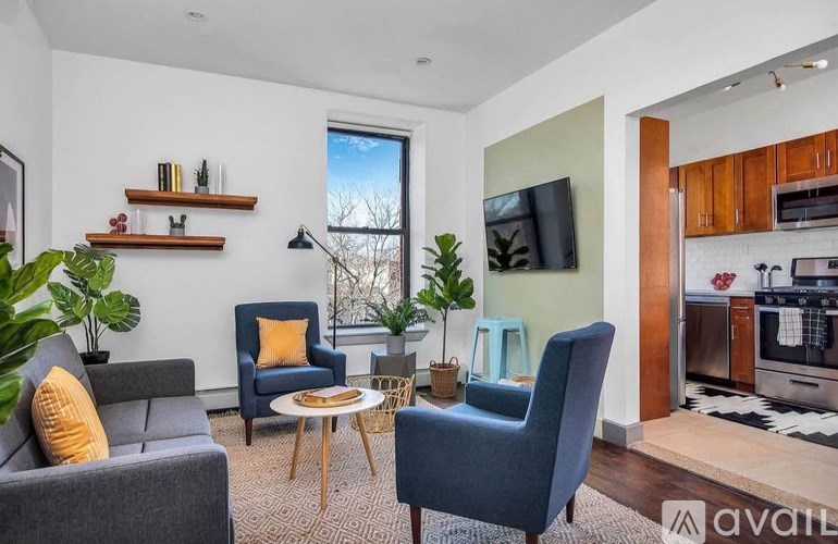A living room with a grey couch, blue chairs, and a television.
