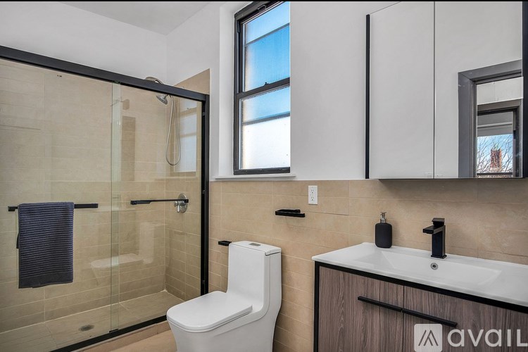 A bathroom with a toilet, sink, and a glass shower stall.