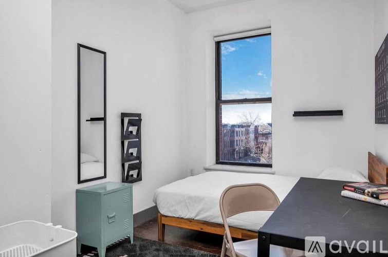 A bedroom with a bed, a chair, a wardrobe, and a window.