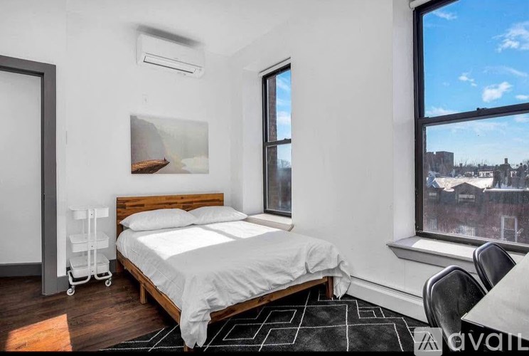 A bedroom with a large bed and a view of the city through the window.
