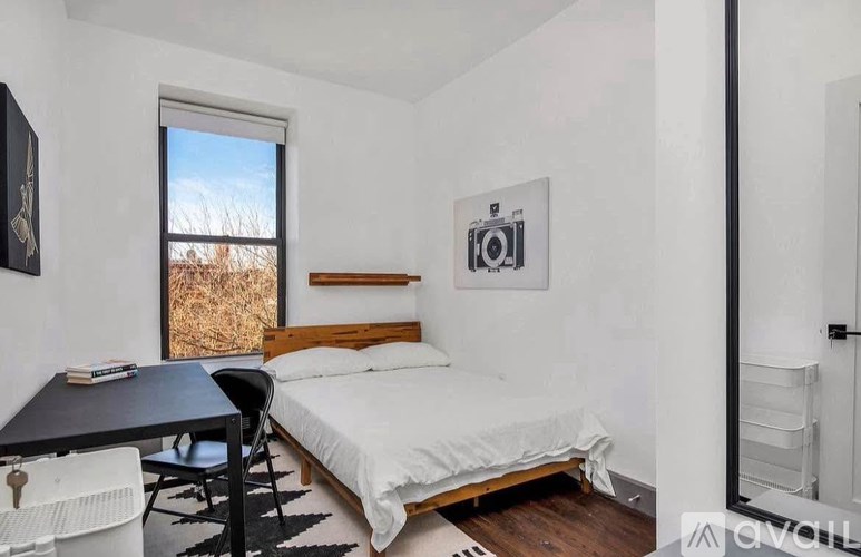 A bedroom with a bed, desk, and chair.