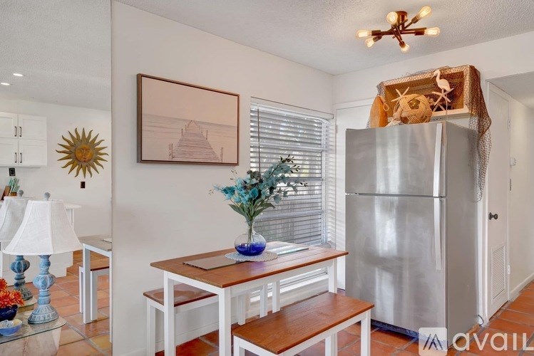 A kitchen with a table and chairs and a fridge.