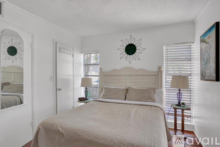 A bedroom with a large bed and two lamps.