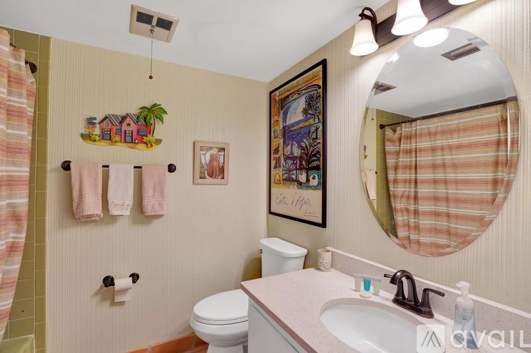 A bathroom with a toilet, sink, and a mirror.