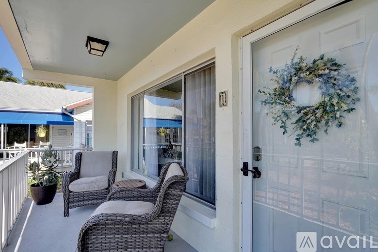 A patio with a wreath on the door and a glass door leading to a balcony.