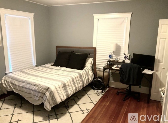 A bedroom with a bed, desk, and chair.