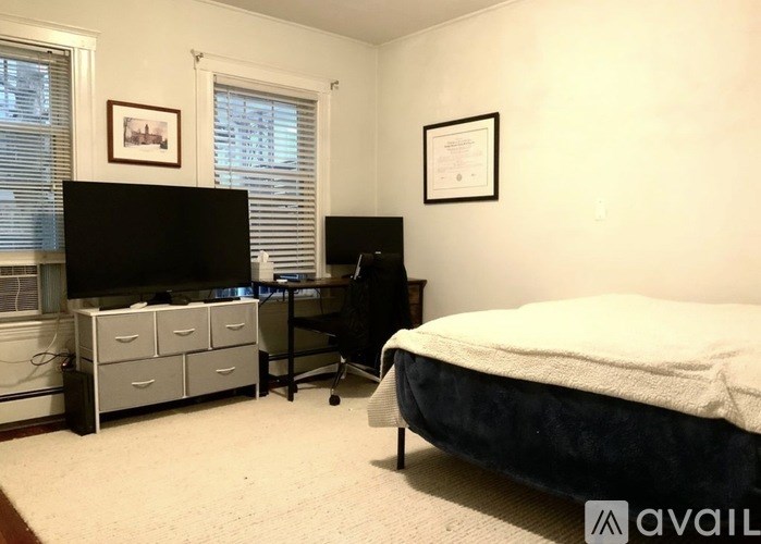 A bedroom with a bed, desk, and chair.