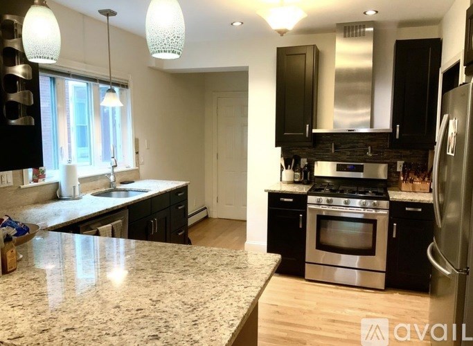 A kitchen with a granite countertop and stainless steel appliances.