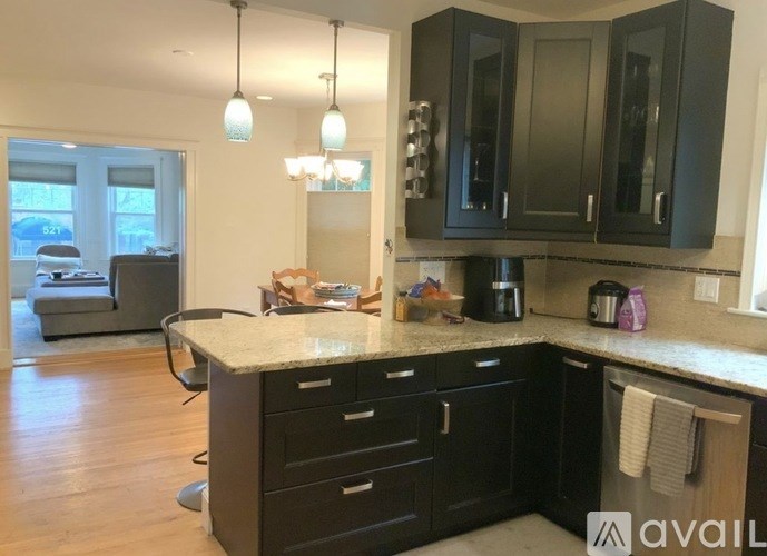 A kitchen with black cabinets and a granite countertop.