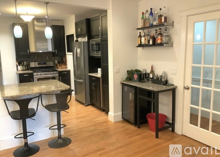A kitchen with black cabinets and a granite countertop.