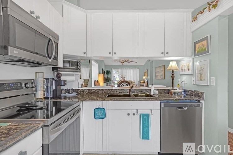 A kitchen with white cabinets and a granite countertop.