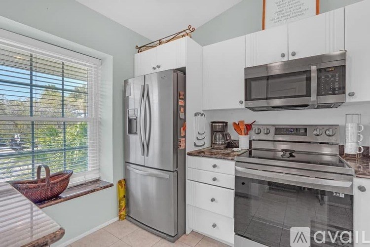 A kitchen with a refrigerator, oven, and microwave.