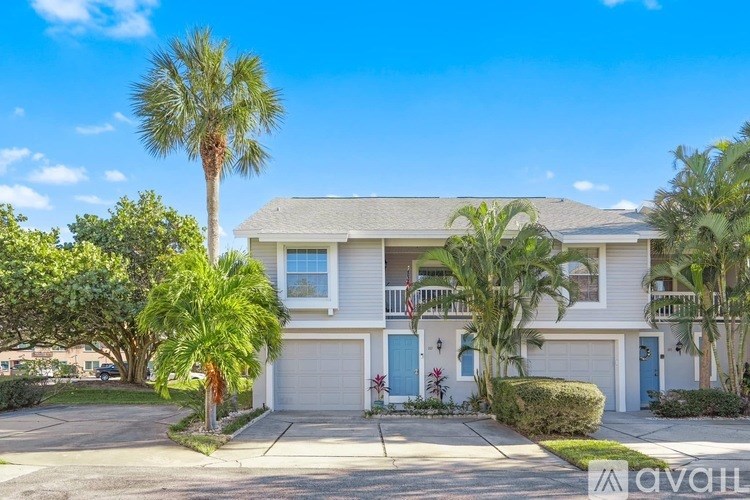 A house with a blue door and a palm tree in front.