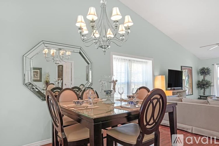 A living room with a beige couch, a white coffee table, and a painting on the wall.