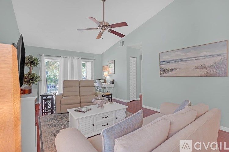 A bedroom with a bed, nightstands, and a ceiling fan.