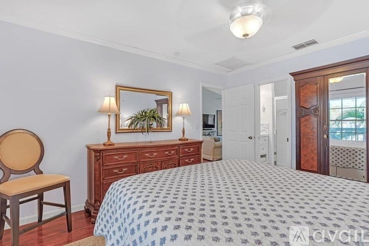 A bedroom with a bed, dresser, and chair.