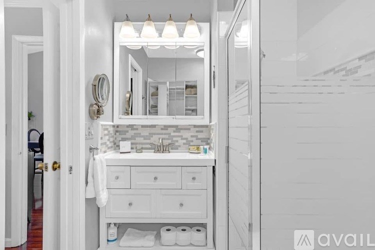 A bathroom with a white sink vanity and a mirror above it.