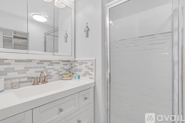 A bathroom with a white sink and a mirror above it.