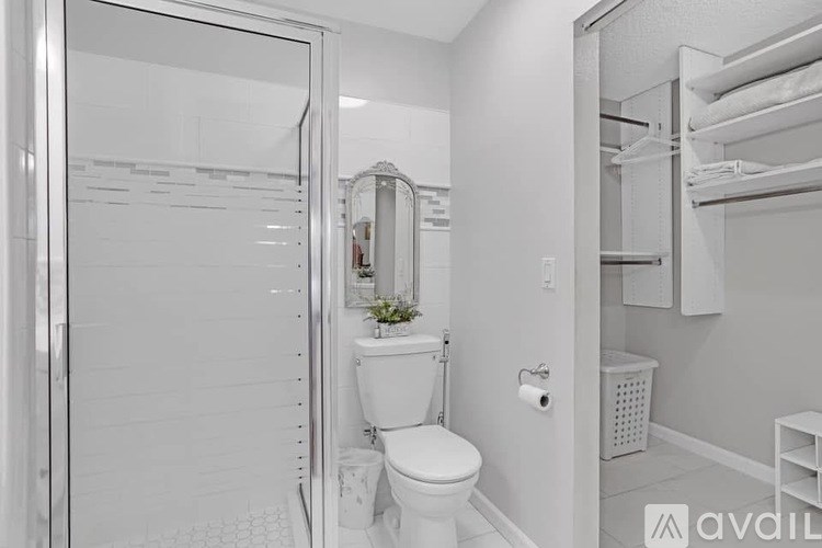 A bathroom with a toilet, sink, and mirror.