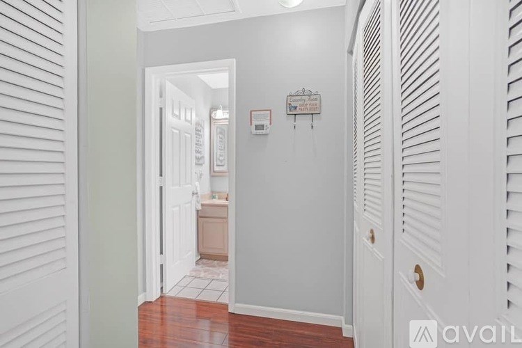 A hallway with a doorway leading to a bathroom.