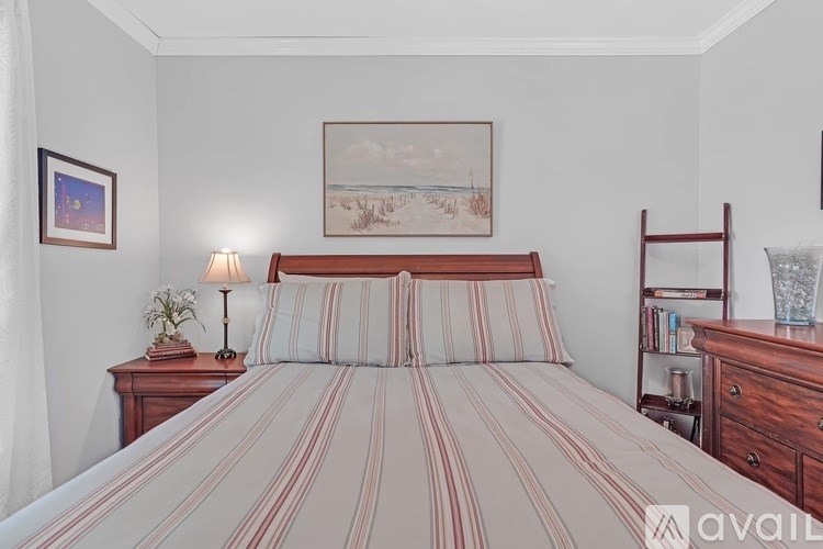 A bedroom with a large bed and a painting on the wall.