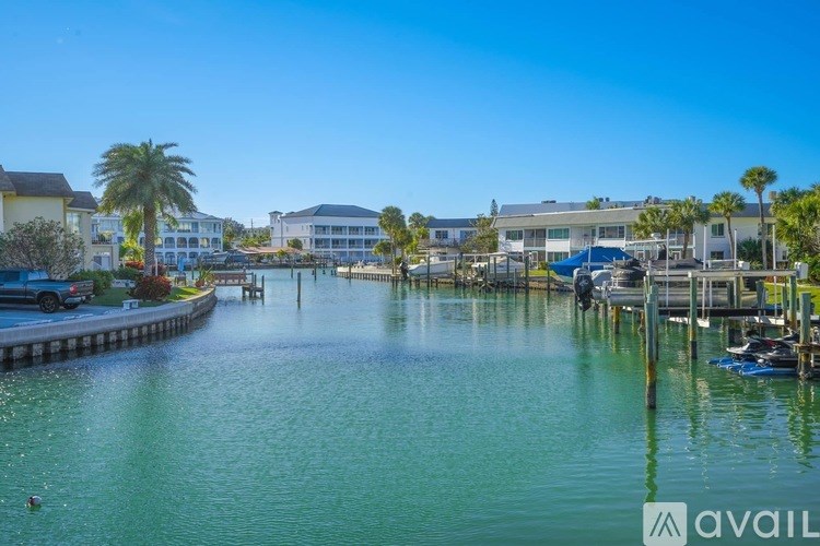 A serene waterfront scene with buildings and palm trees.