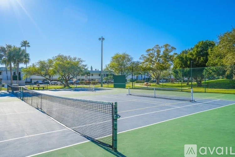 A tennis court with a net and trees in the background.