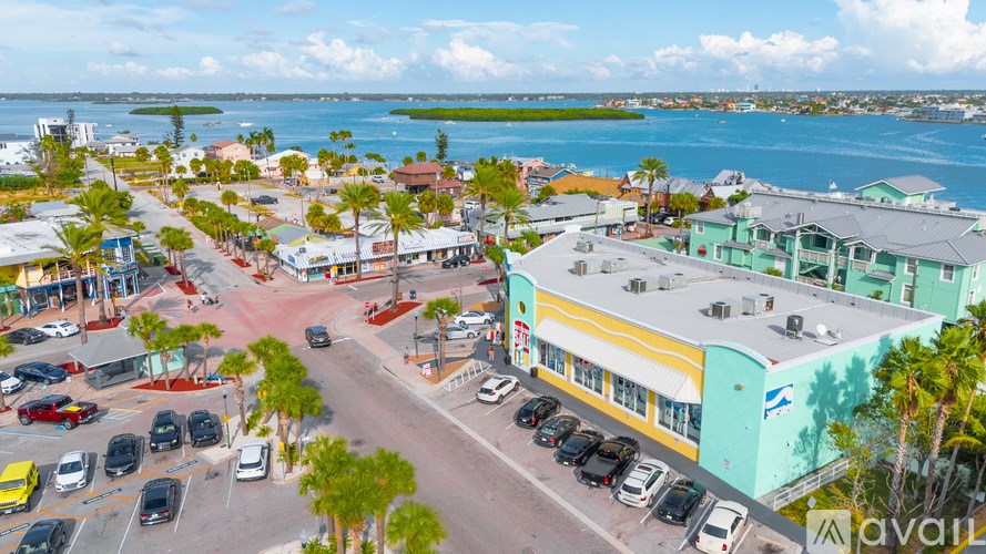 A parking lot with cars and a building with a yellow and green facade.