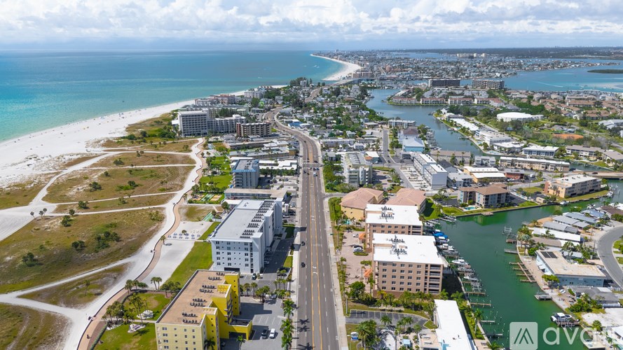 A view of a beachfront area with buildings, a road, and a body of water.