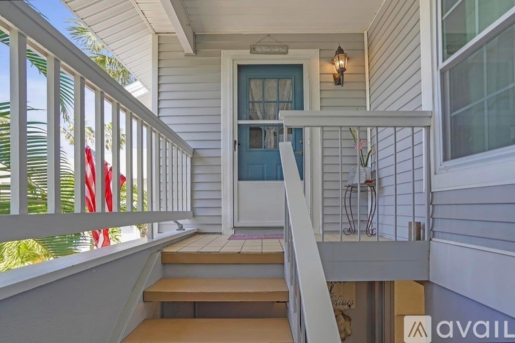 A house with a blue door and a white railing.