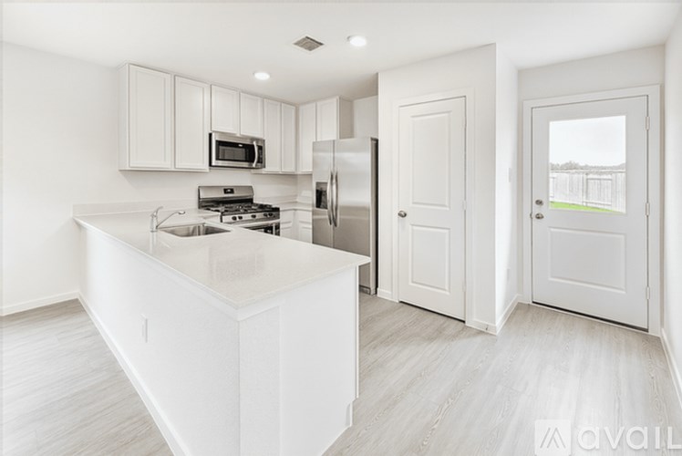 A modern kitchen with white cabinets and appliances.