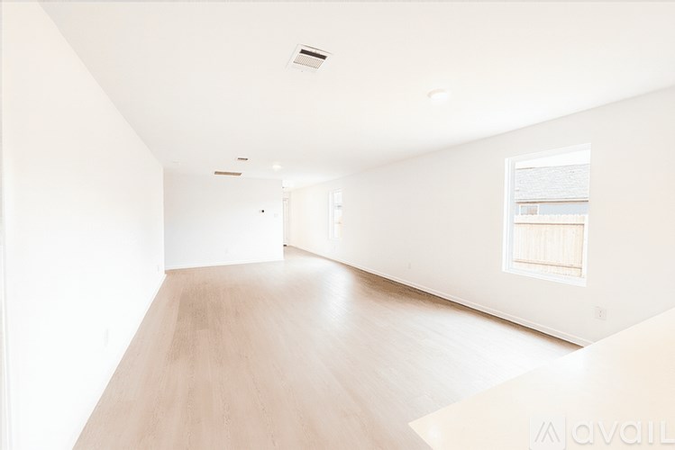 A white room with wooden floors and a window.