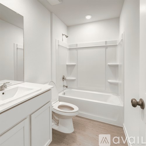 A white bathroom with a toilet, sink, and bathtub.
