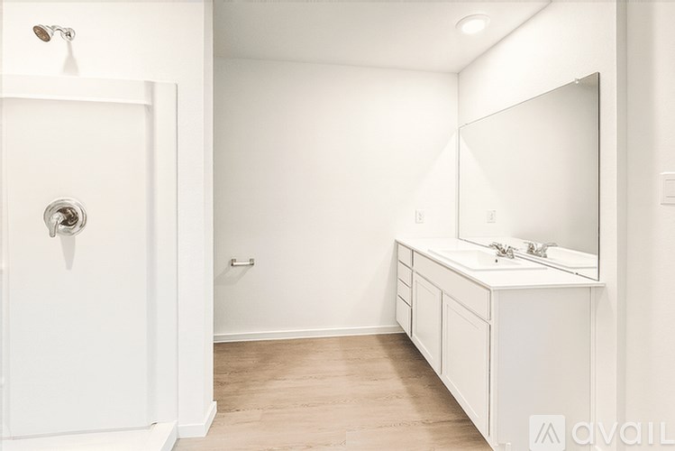A white bathroom with a sink and mirror.