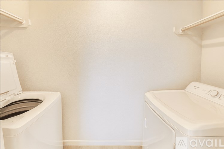 A small laundry room with a washer and dryer.