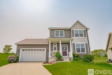 A house with a garage and a front porch is available for sale.