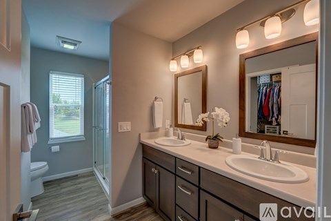 A bathroom with a large mirror, a sink, and a shower.
