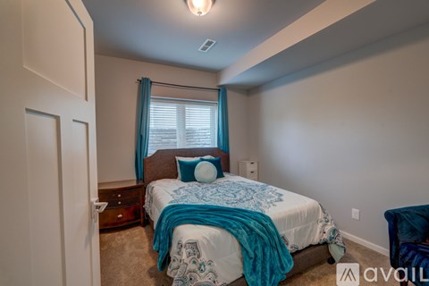 A bedroom with a bed covered in a blue and white patterned bedspread.