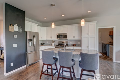 A kitchen with a black wall and white cabinets.
