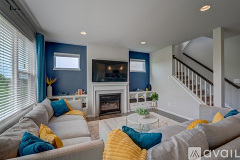 A living room with a grey couch and a fireplace.