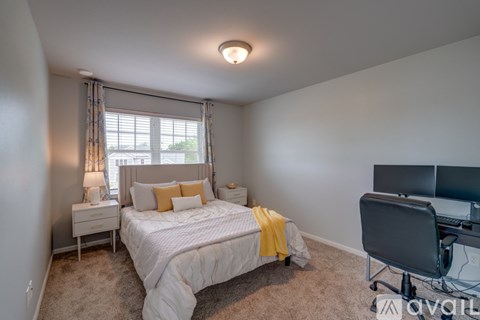 A bedroom with a bed, desk, and chair.