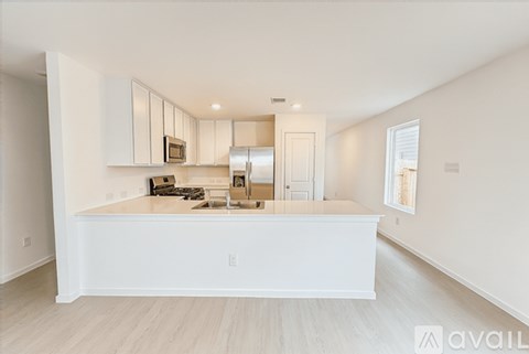 A kitchen with white cabinets and a white island.