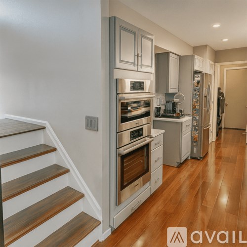 A kitchen with wooden floors and stainless steel appliances.